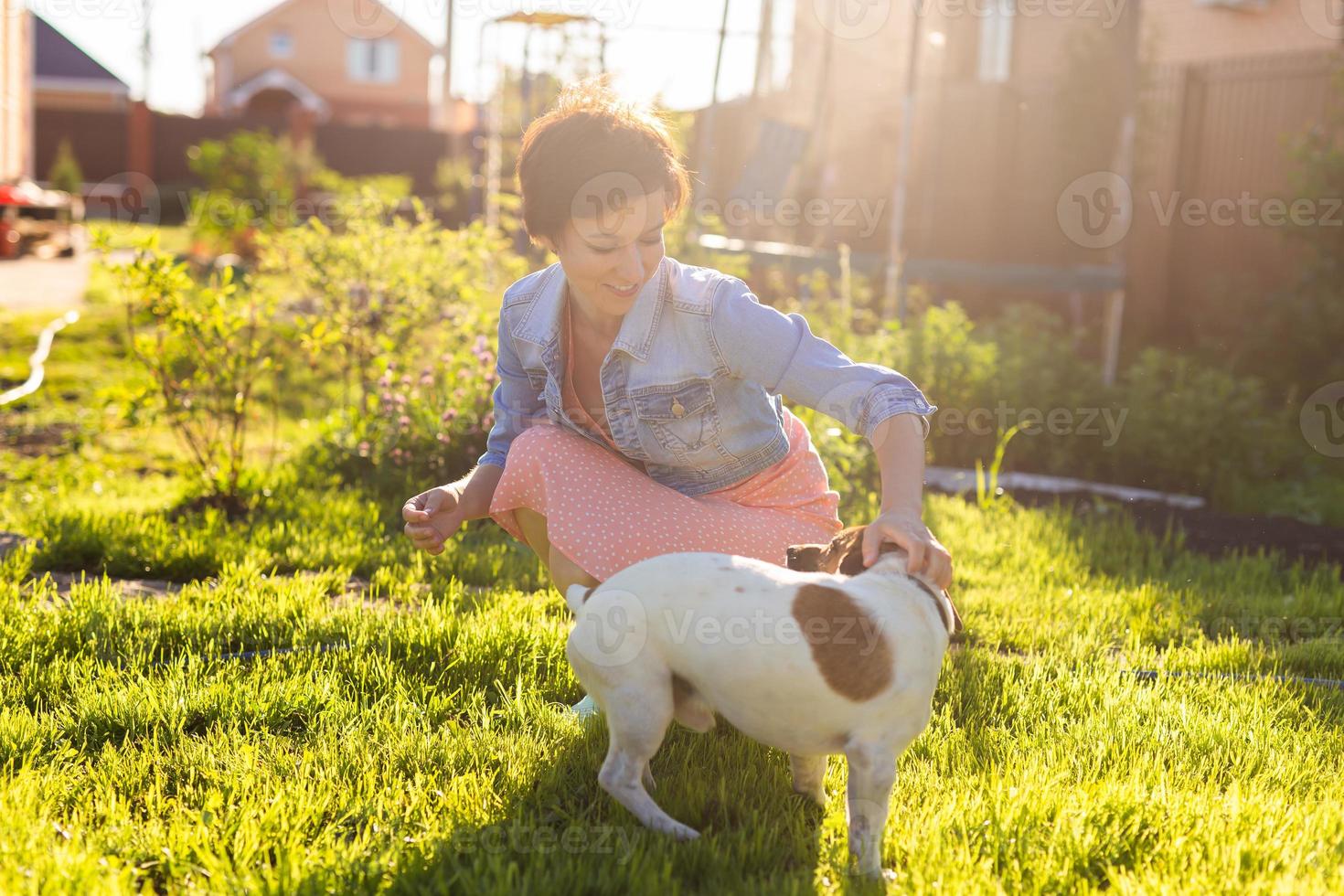 jovem brinca com seu cachorro na grama no quintal. o conceito de animais e amizade ou dono de animais e amor foto