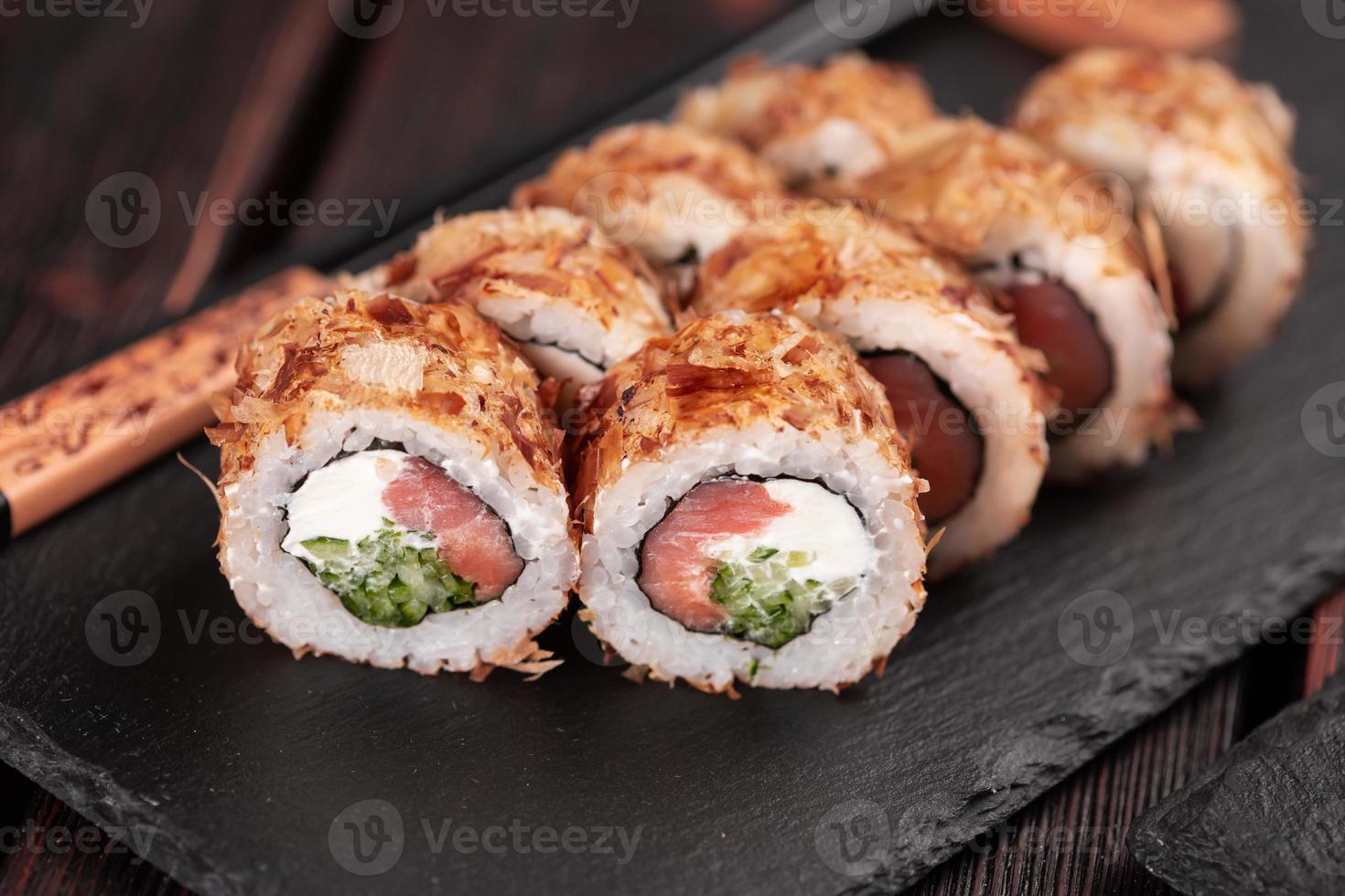 rolo de sushi de salmão com close-up de flocos de atum - menu asiático de sushi e comida japonesa foto