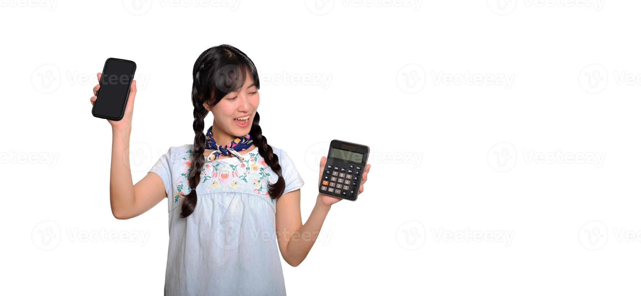 retrato da bela jovem mulher asiática em vestido jeans segurando calculadora e smartphone em fundo branco. conceito on-line de compras de negócios. foto