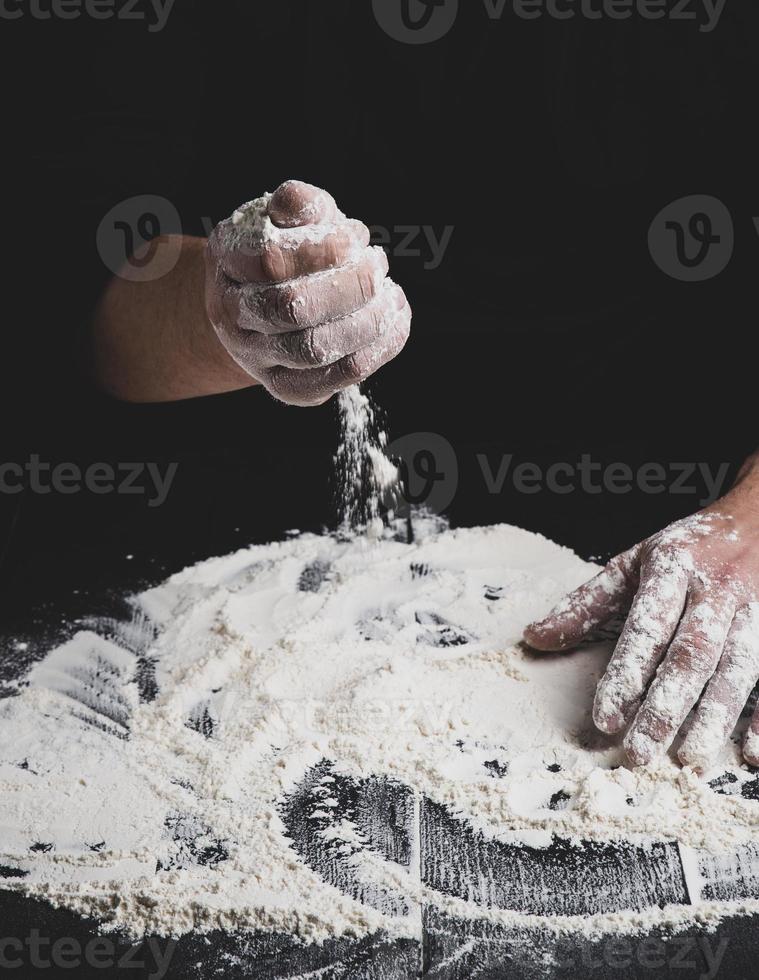 farinha de trigo branca em uma mesa de madeira preta foto