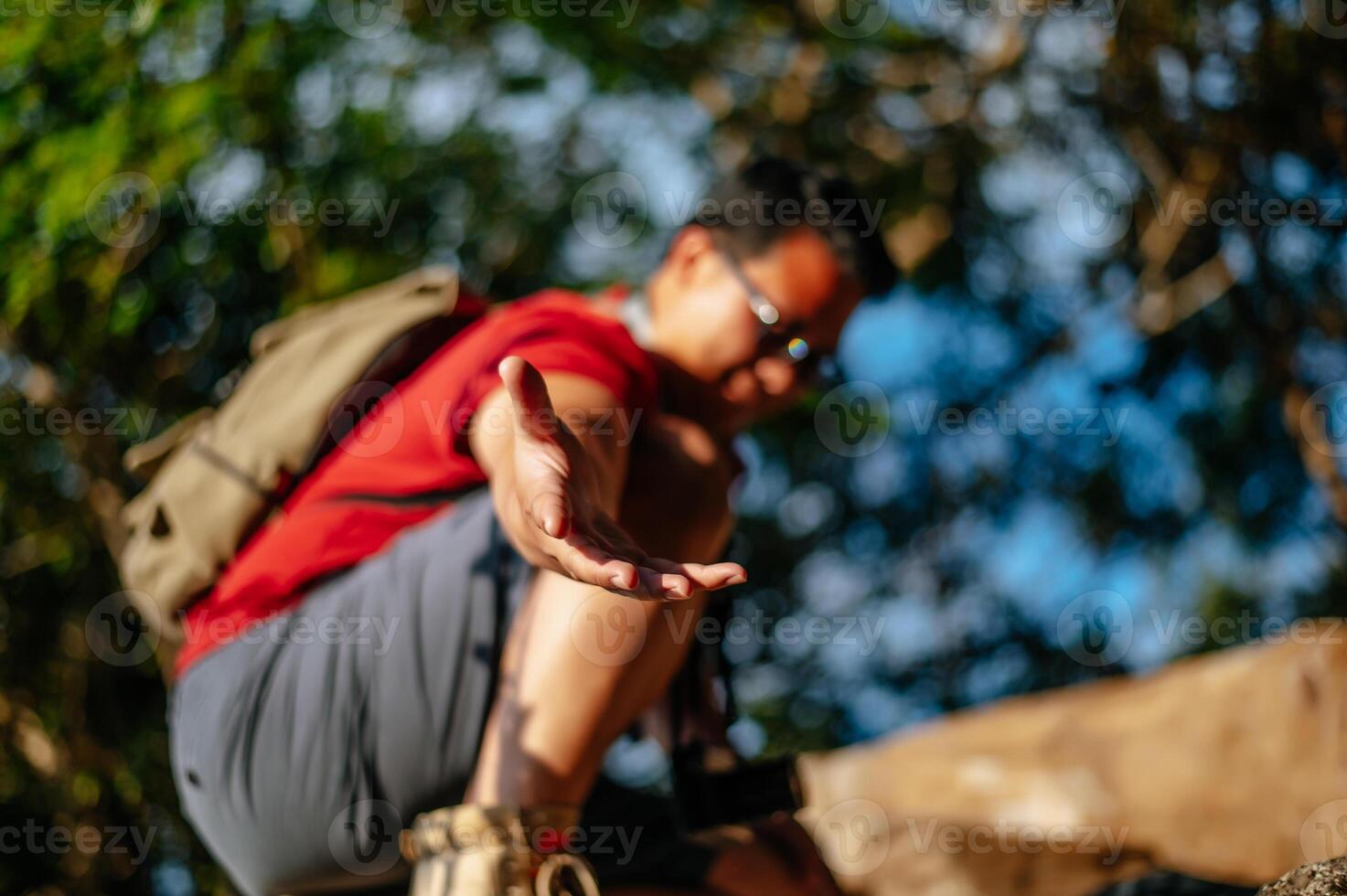 jovem alpinista segura a mão de alguém ajuda a subir foto