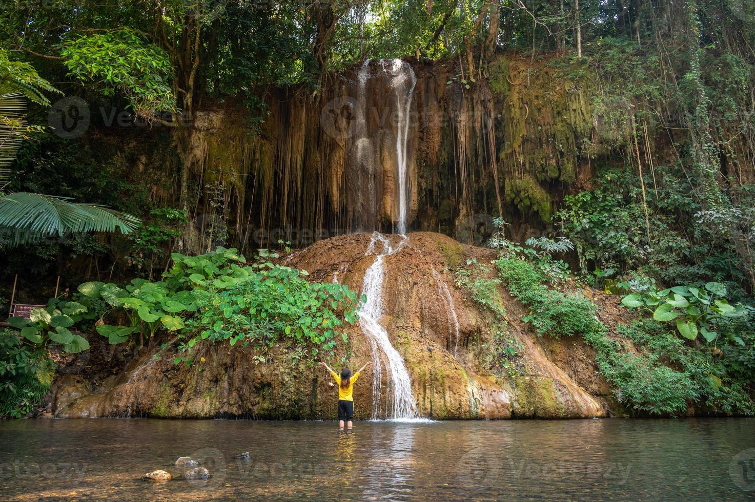 turista em frente à cachoeira phu sang a única cachoeira quente na tailândia com temperatura de cerca de 35 graus celsius. situado na fronteira da província de Phayao e Chiang Rai. foto