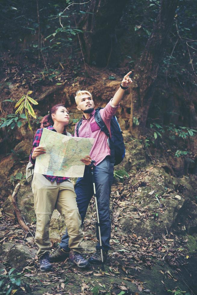jovem casal de turistas viajando de férias na floresta foto