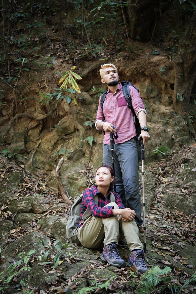 jovem casal de turistas caminhando na floresta foto