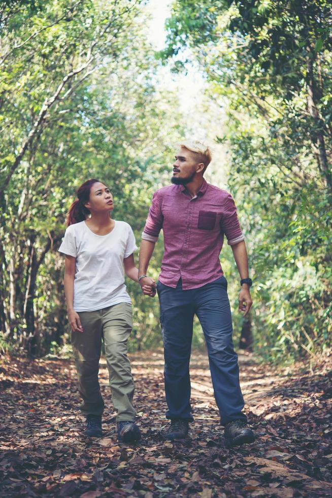 jovem casal atraente caminhando na floresta foto