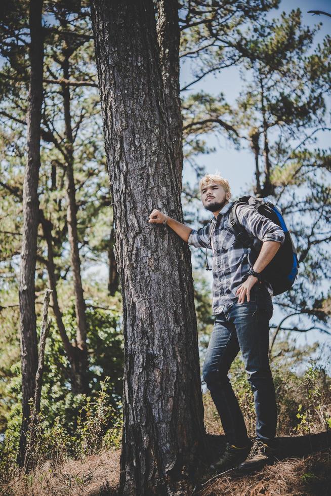 jovem viajando com uma mochila na natureza foto