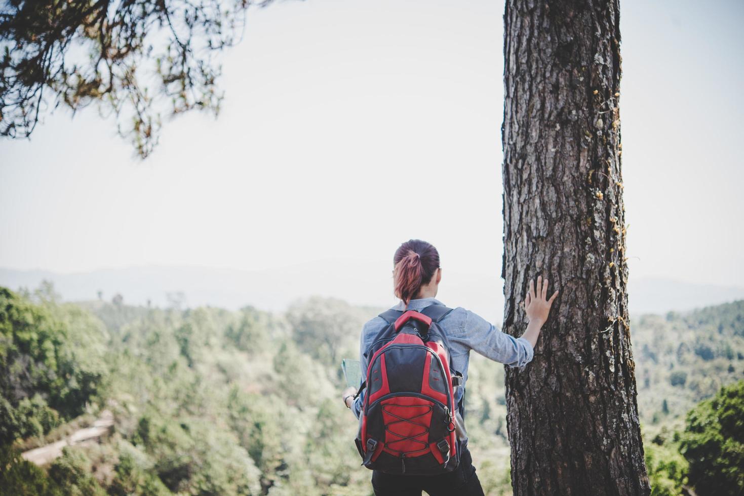 alpinista com mochila no topo de uma montanha foto