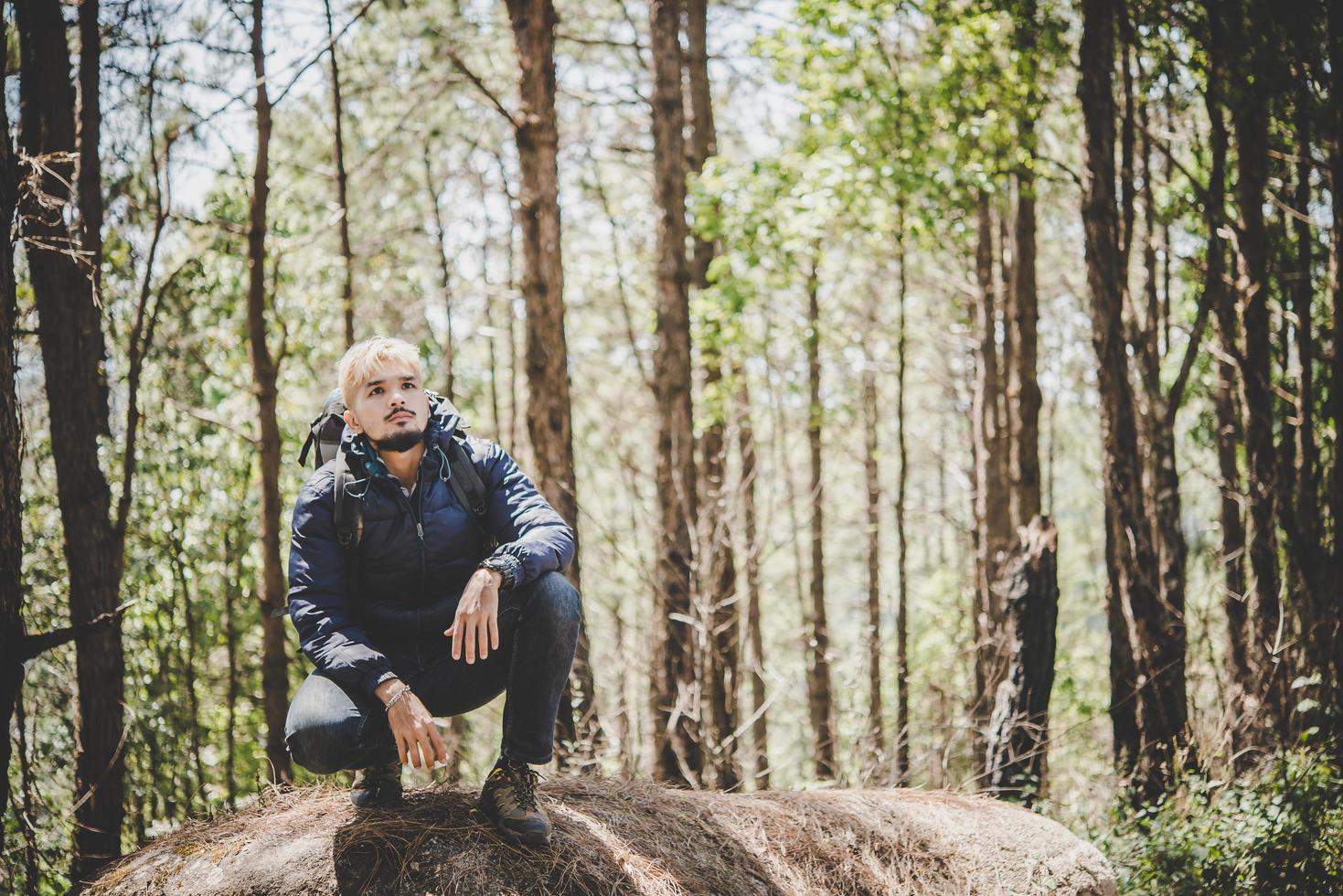 homem no topo da montanha sentado na rocha foto