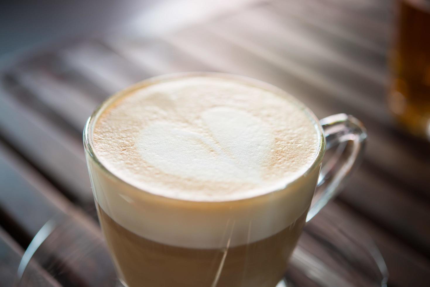 close-up de xícara de cappuccino com padrão de leite em forma de coração foto