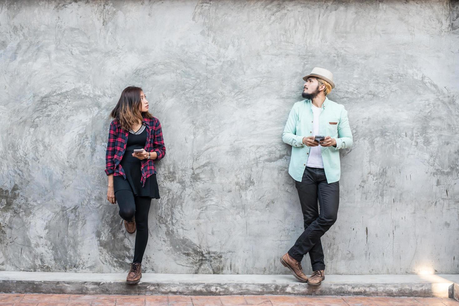 casal conversando com um celular na parede de tijolos, fundo vintage, grunge foto
