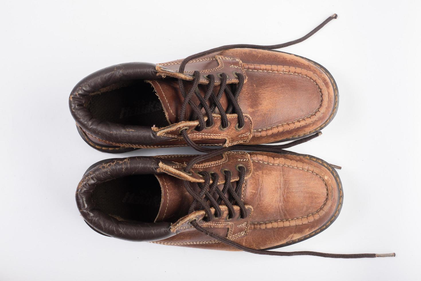 par de botas marrons velhas isoladas em um fundo branco foto