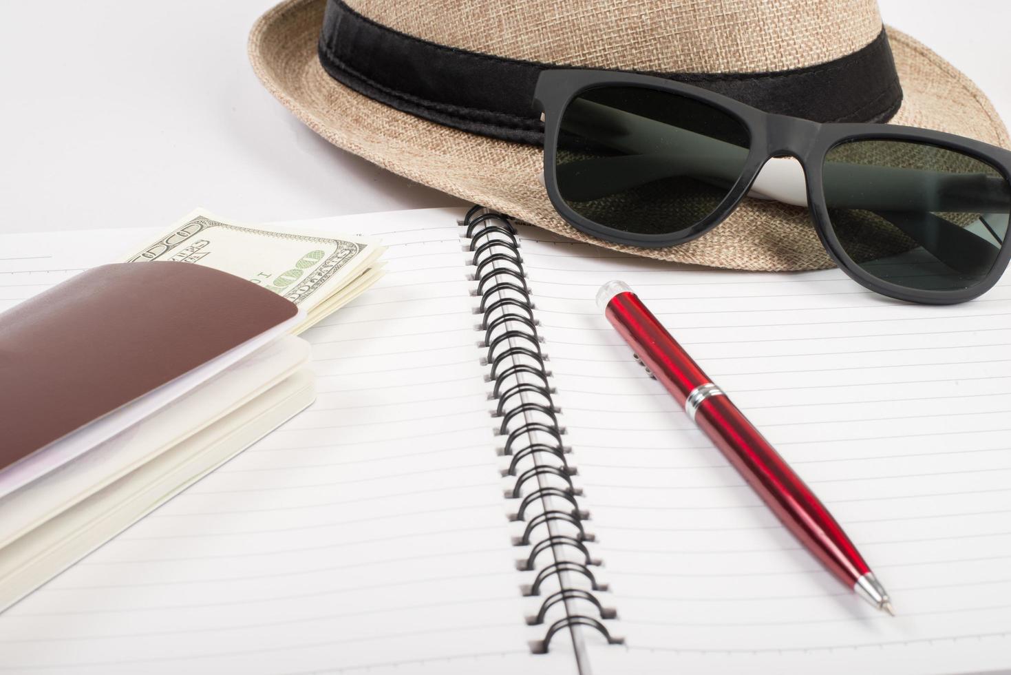 passaportes, chapéu, câmera, óculos e caneta no chão de papel prontos para viajar foto