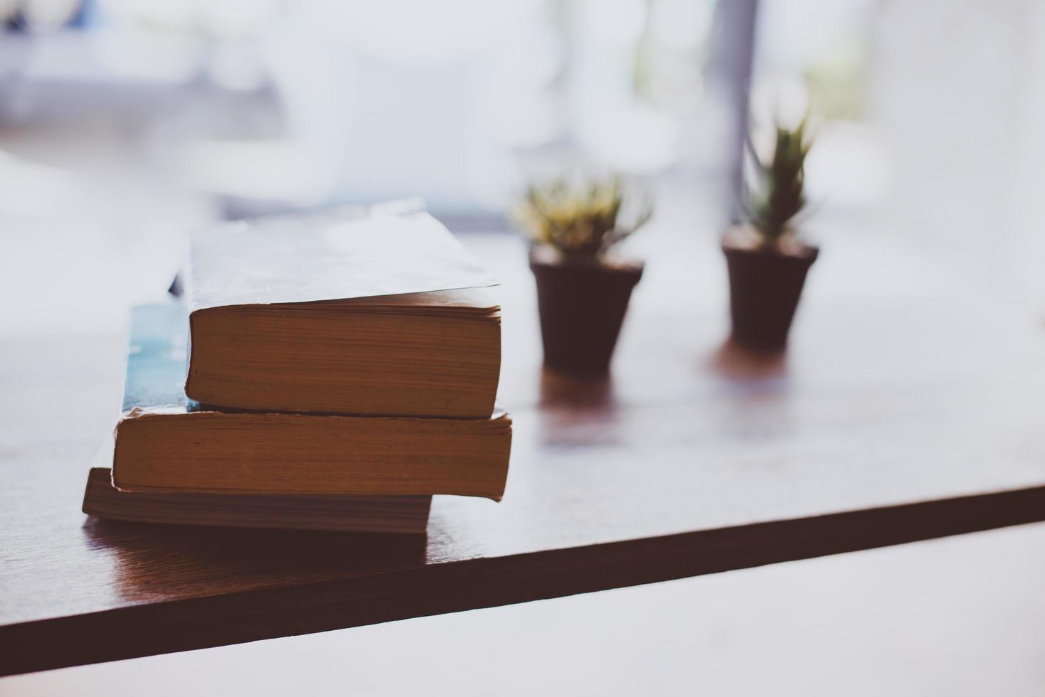 flor de cacto com uma pilha de livros na mesa de madeira foto