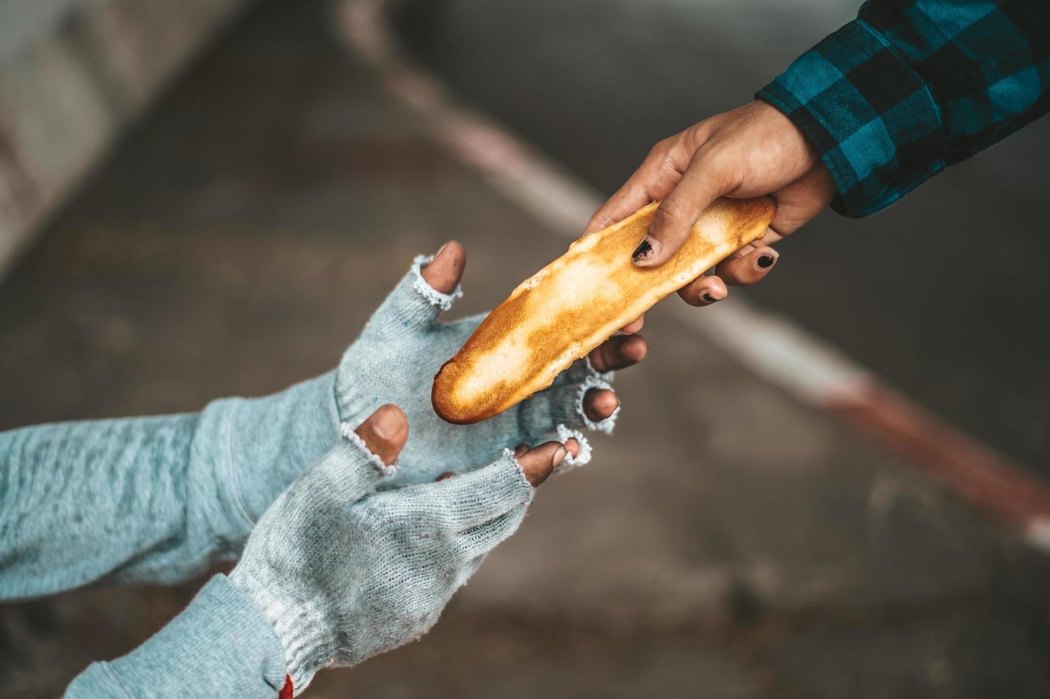 um fazedor de pão dá a um mendigo foto