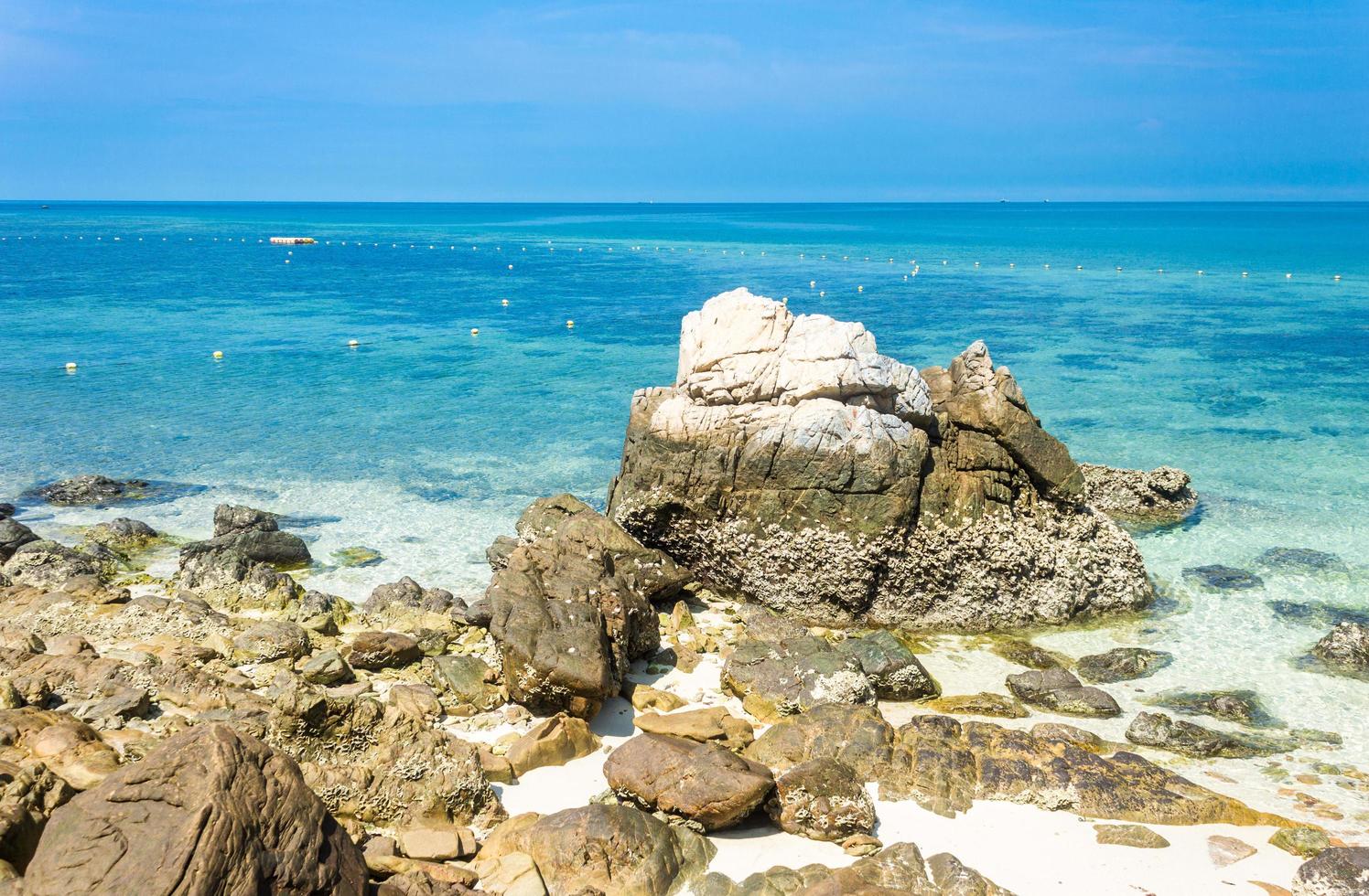 ilha tropical na praia com água azul clara e céu azul nublado foto