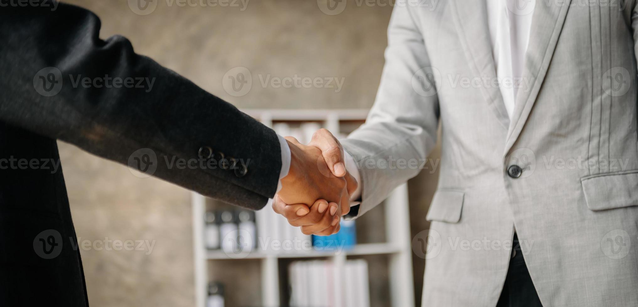 dois homens de negócios confiantes apertando as mãos durante uma reunião no escritório, sucesso, negociação, saudação e parceiro na luz do sol foto