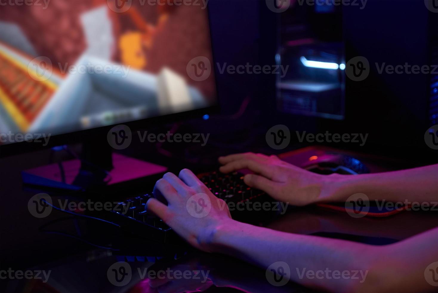 jogador joga jogo de computador, usa teclado colorido neon rgb foto