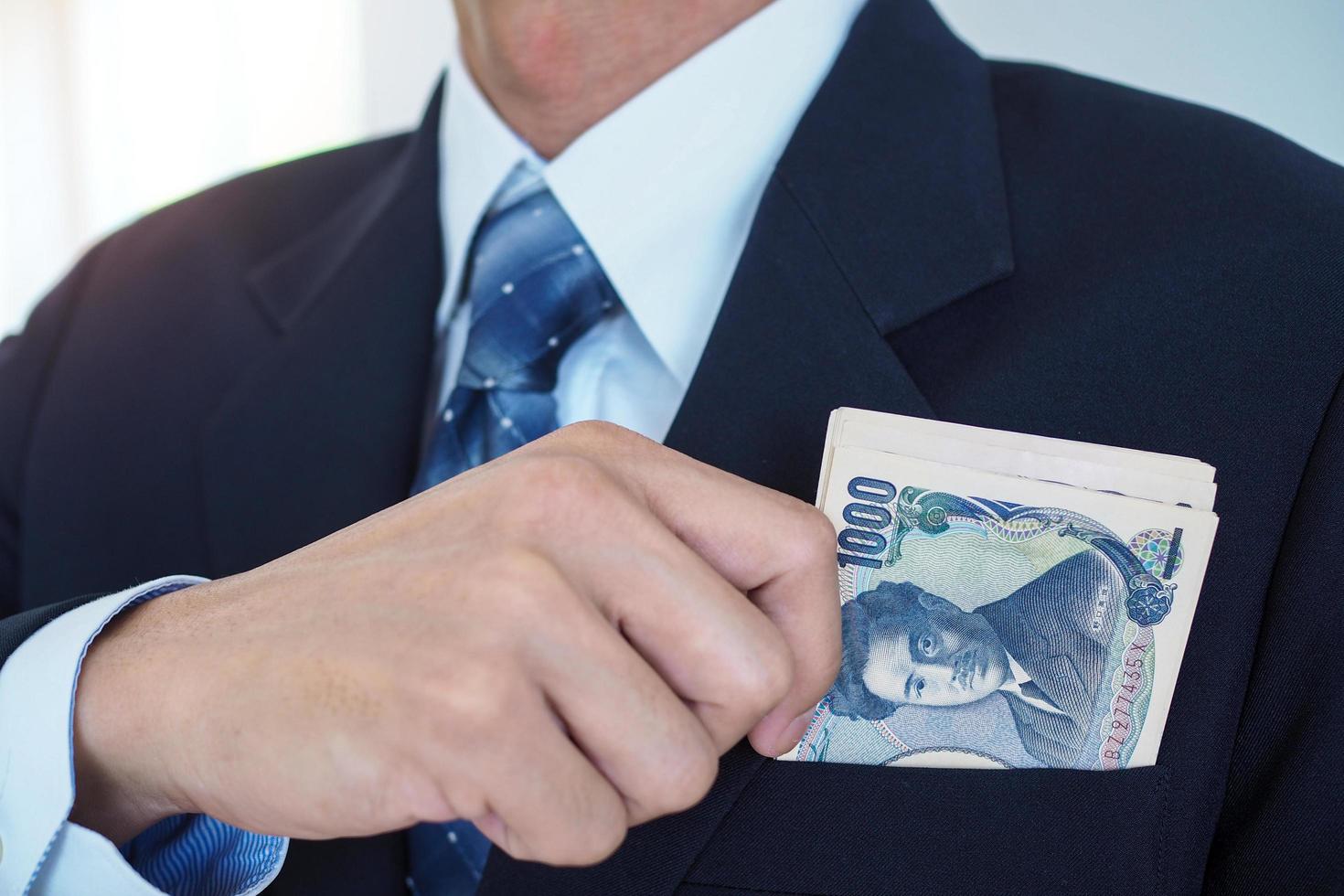 notas de ienes na bolsa de um empresário. dinheiro recebido ilegalmente, dinheiro de suborno e conceitos de fraude foto