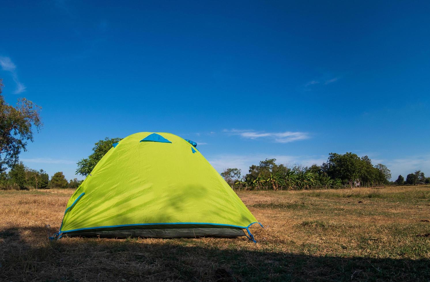 viajante tenda verde acampamento viagens ao ar livre. vista da tenda dentro do sol do céu azul na paisagem de verão. durante a noite do dia adequado para dormir e descansar o corpo foto