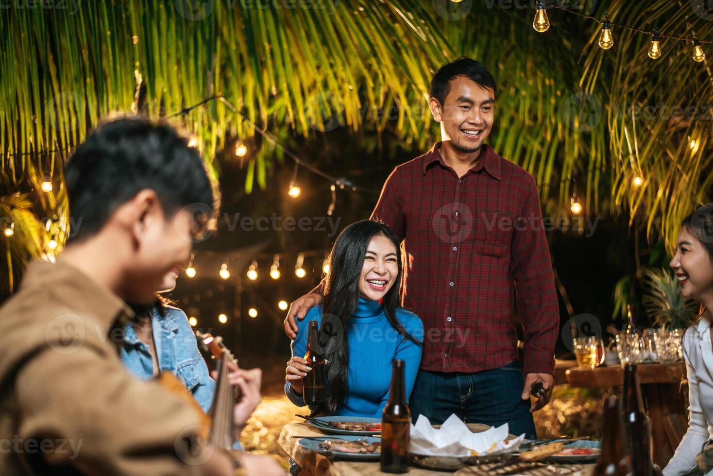 retrato de grupo asiático feliz de amigos se divertindo com música jantando e bebendo juntos ao ar livre - grupo de amigos felizes brindando cervejas - pessoas, comida, estilo de vida de bebida, conceito de celebração de ano novo. foto