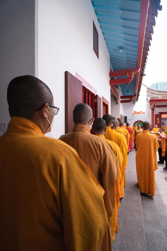 bandung, indonésia, 2020 - os monges em laranja vestem-se em ordem enquanto rezam ao deus no altar dentro do templo de buda foto