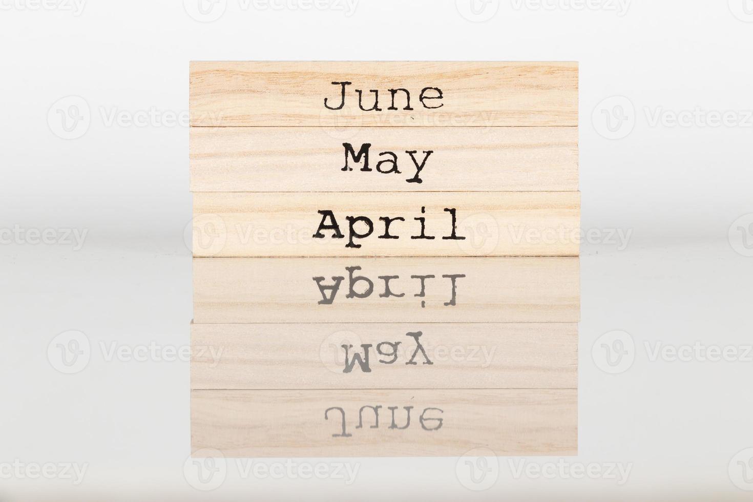 cubo de madeira com a inscrição abril, maio, junho em um fundo branco foto