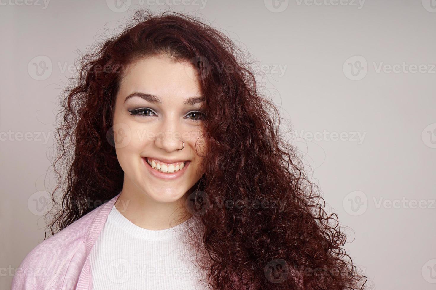 adolescente sorridente com cabelo cacheado foto