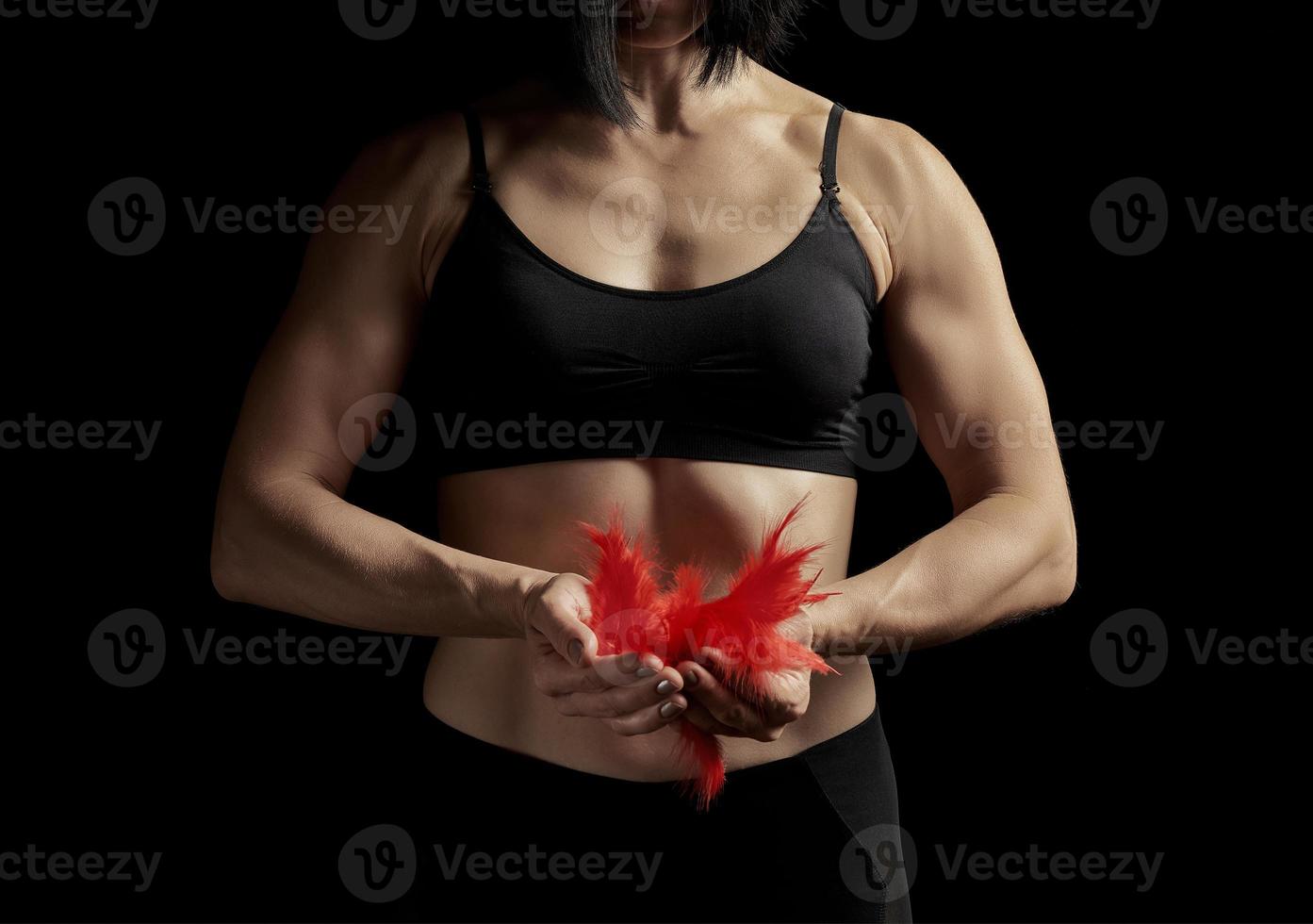 jovem com um corpo musculoso e atlético está vestida com um top preto e leggings foto