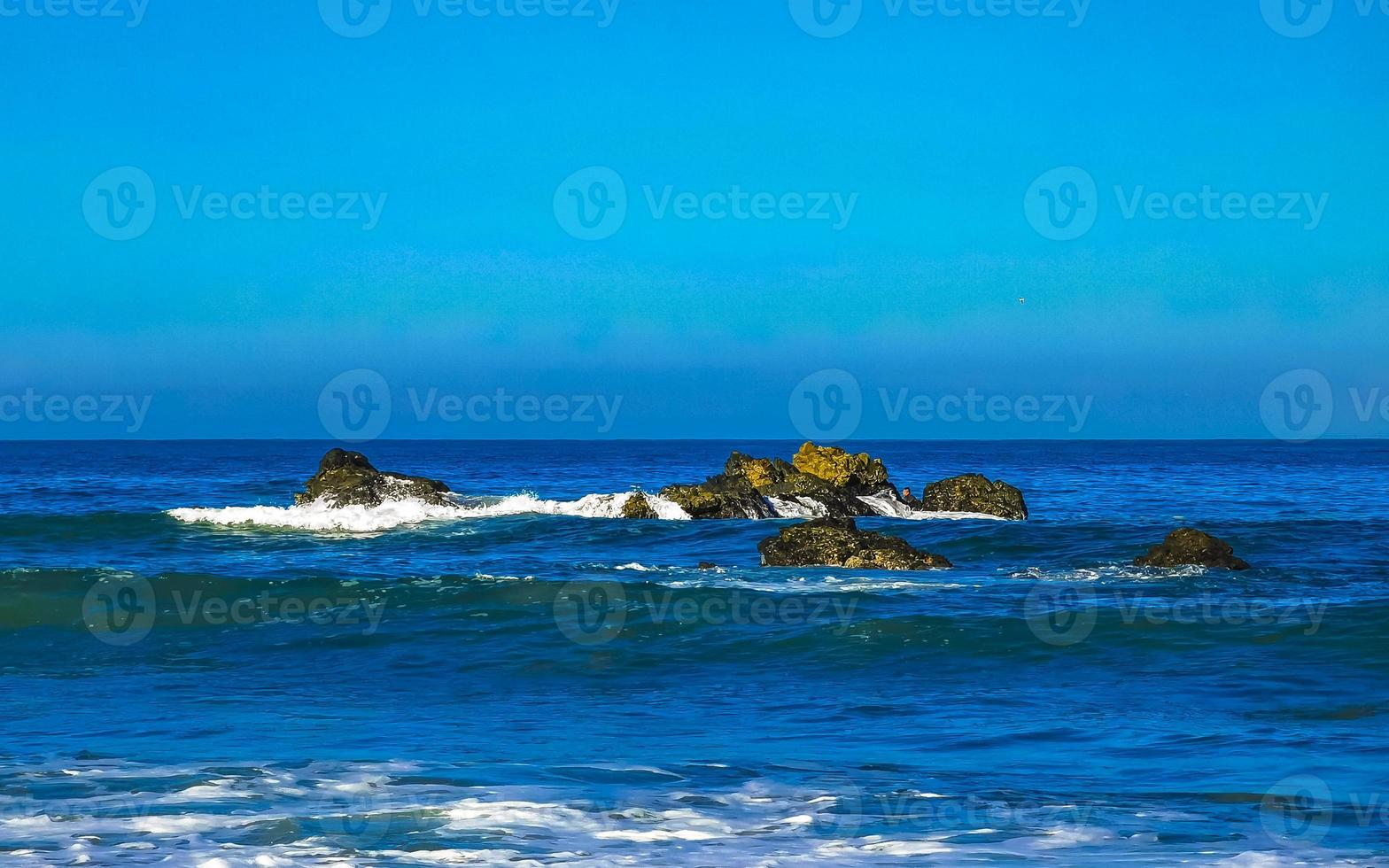 belas rochas falésias surfista ondas na praia puerto escondido méxico. foto