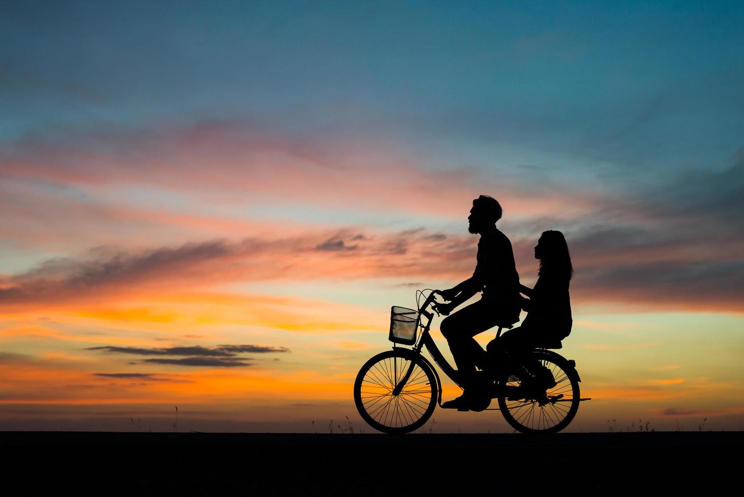 silhueta de um jovem casal junto durante o pôr do sol foto