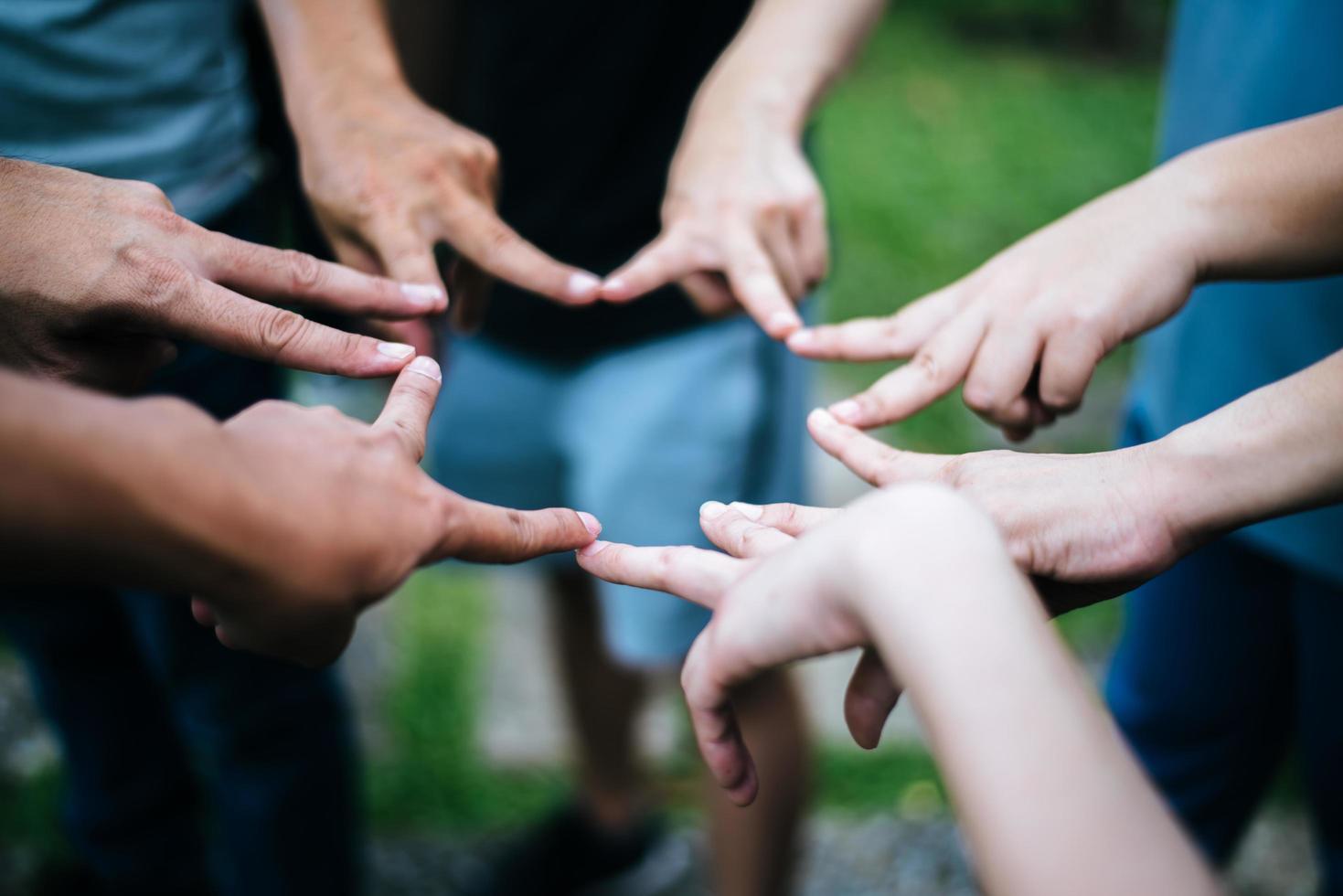 amigos fazem formato de estrela juntos com os dedos foto