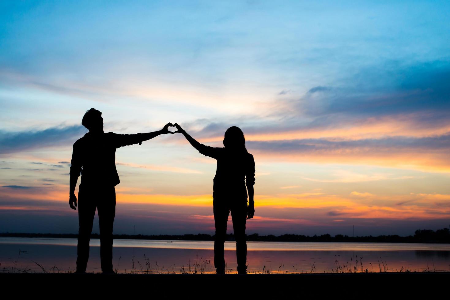 silhueta de um jovem casal durante o pôr do sol foto