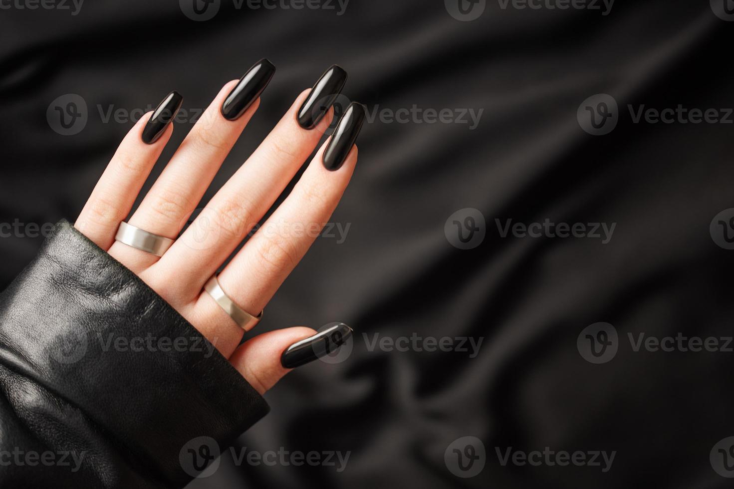 mãos de uma jovem com manicure preta nas unhas foto