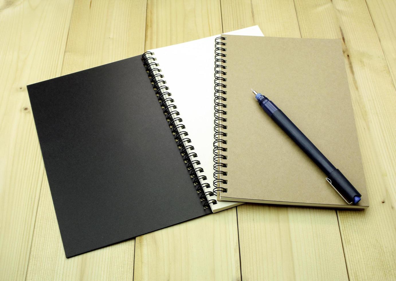 cadernos e uma caneta foto