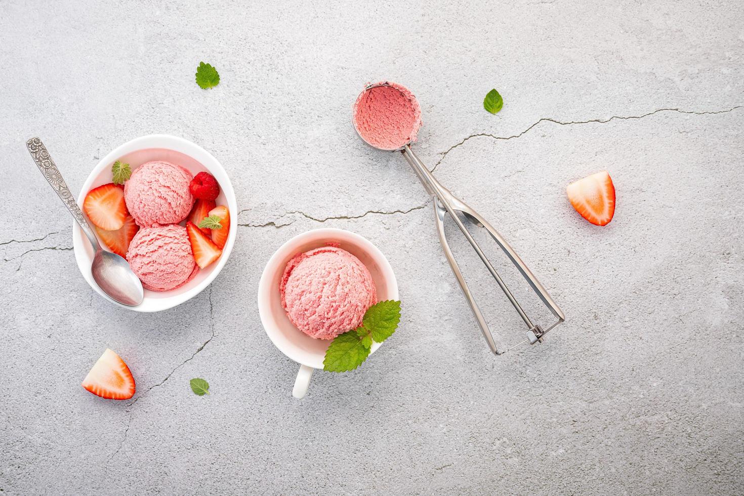 sabor de sorvete de morango em tigela branca configurada em fundo de concreto foto