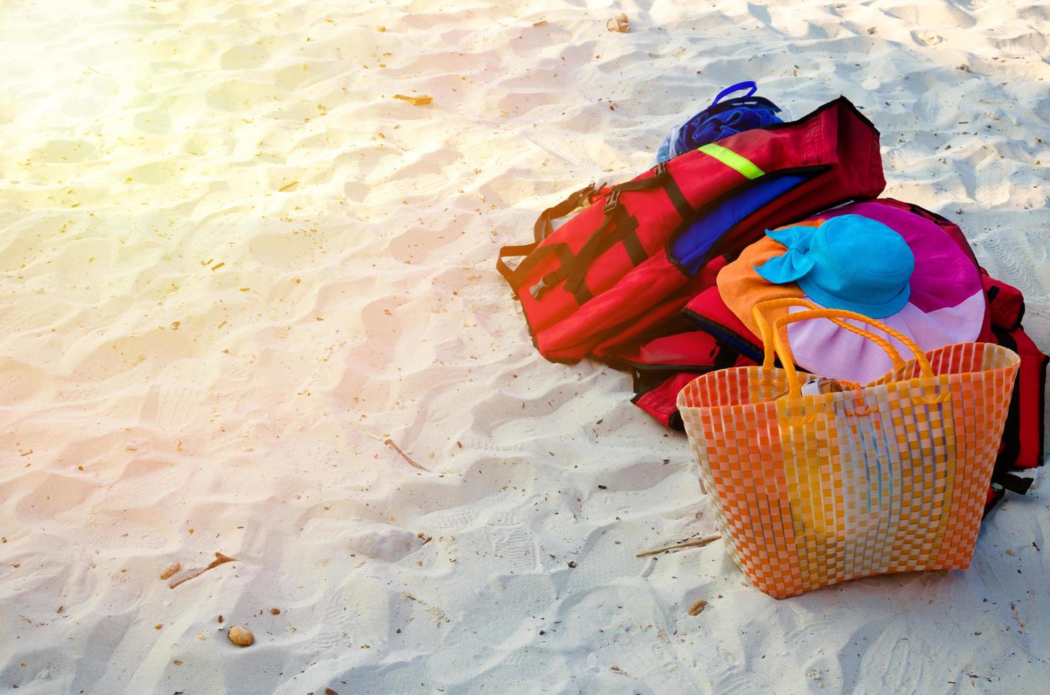 chapéu de palha e bolsa na praia foto