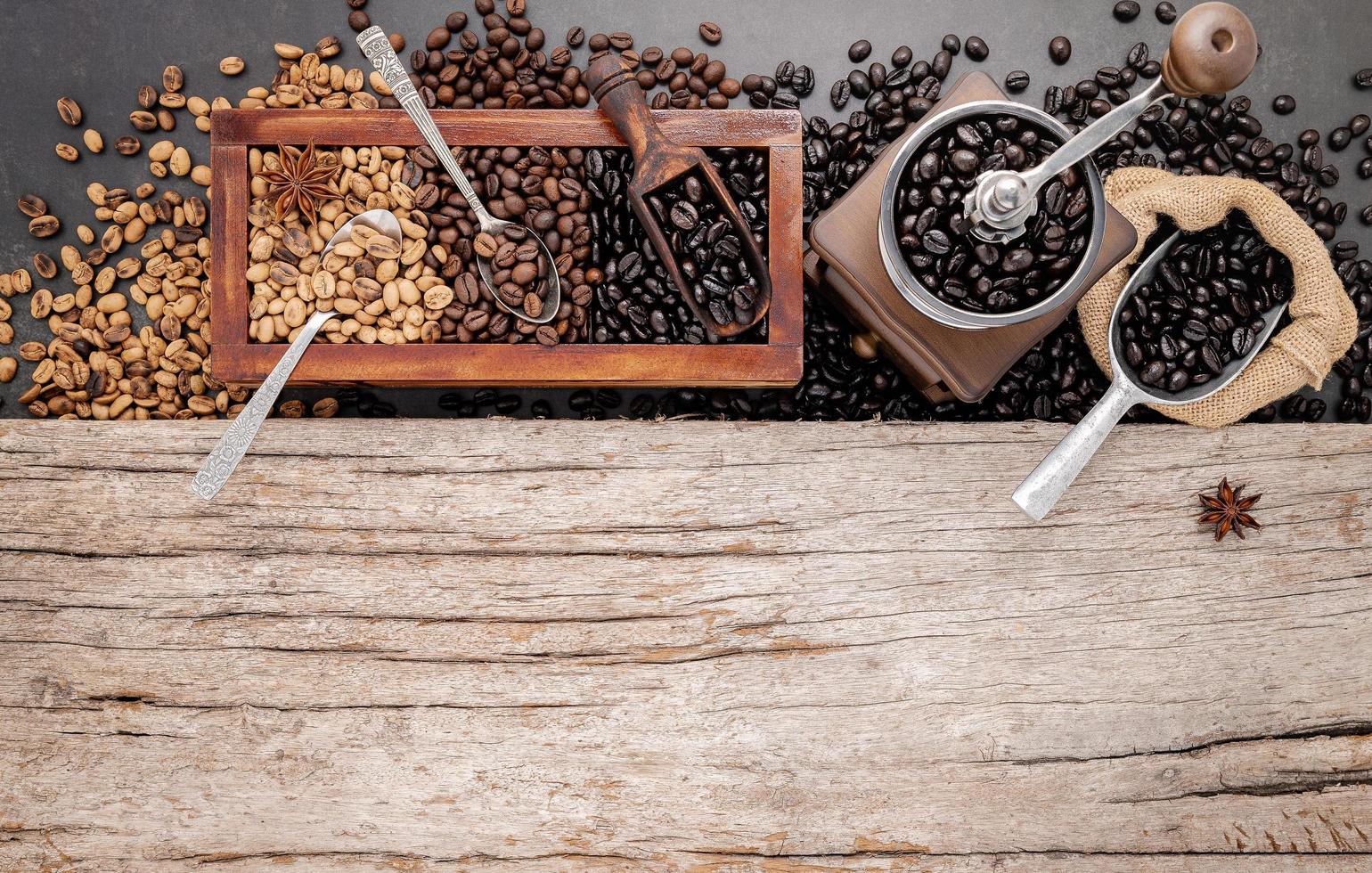 vários tipos de grãos de café torrados em caixa de madeira com moedor de café manual foto