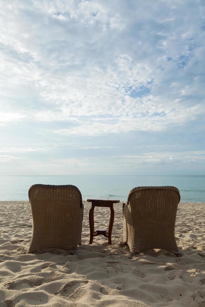 cadeiras e mesa na praia foto