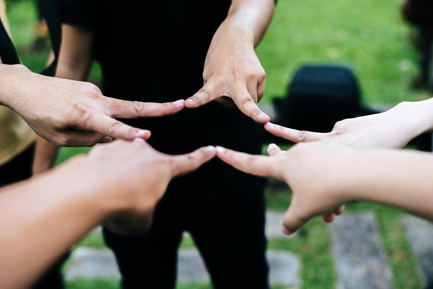 amigos fazem formato de estrela juntos com os dedos foto