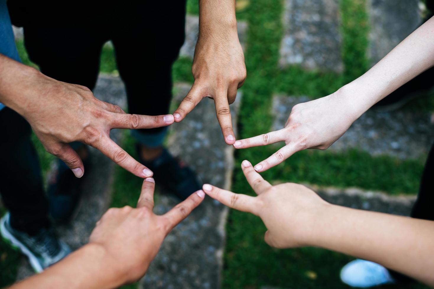 amigos fazem formato de estrela juntos com os dedos foto