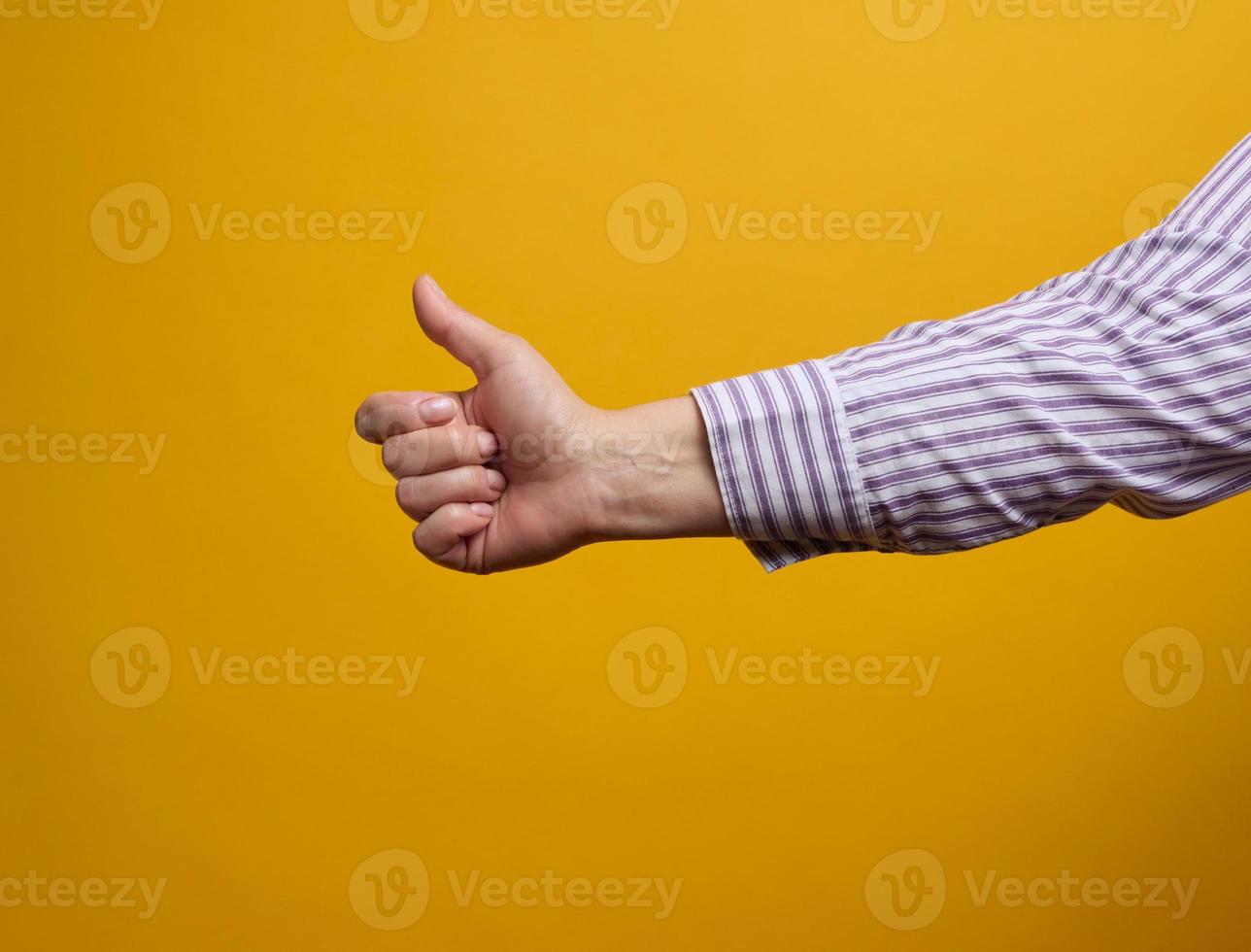 fêmea mão mostra gostar gesto em amarelo fundo. aprovação conceito foto