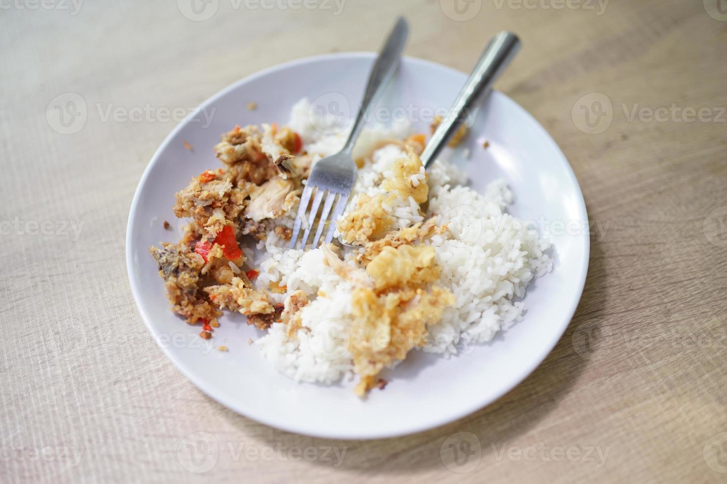 frango geprek com arroz branco quente em fundo de madeira foto