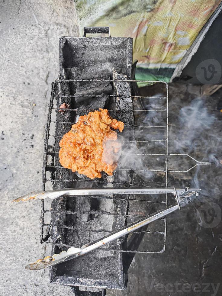 peito de frango envolto em farinha crocante com delicioso tempero picante na grelha quente.típico frango grelhado da indonésia foto