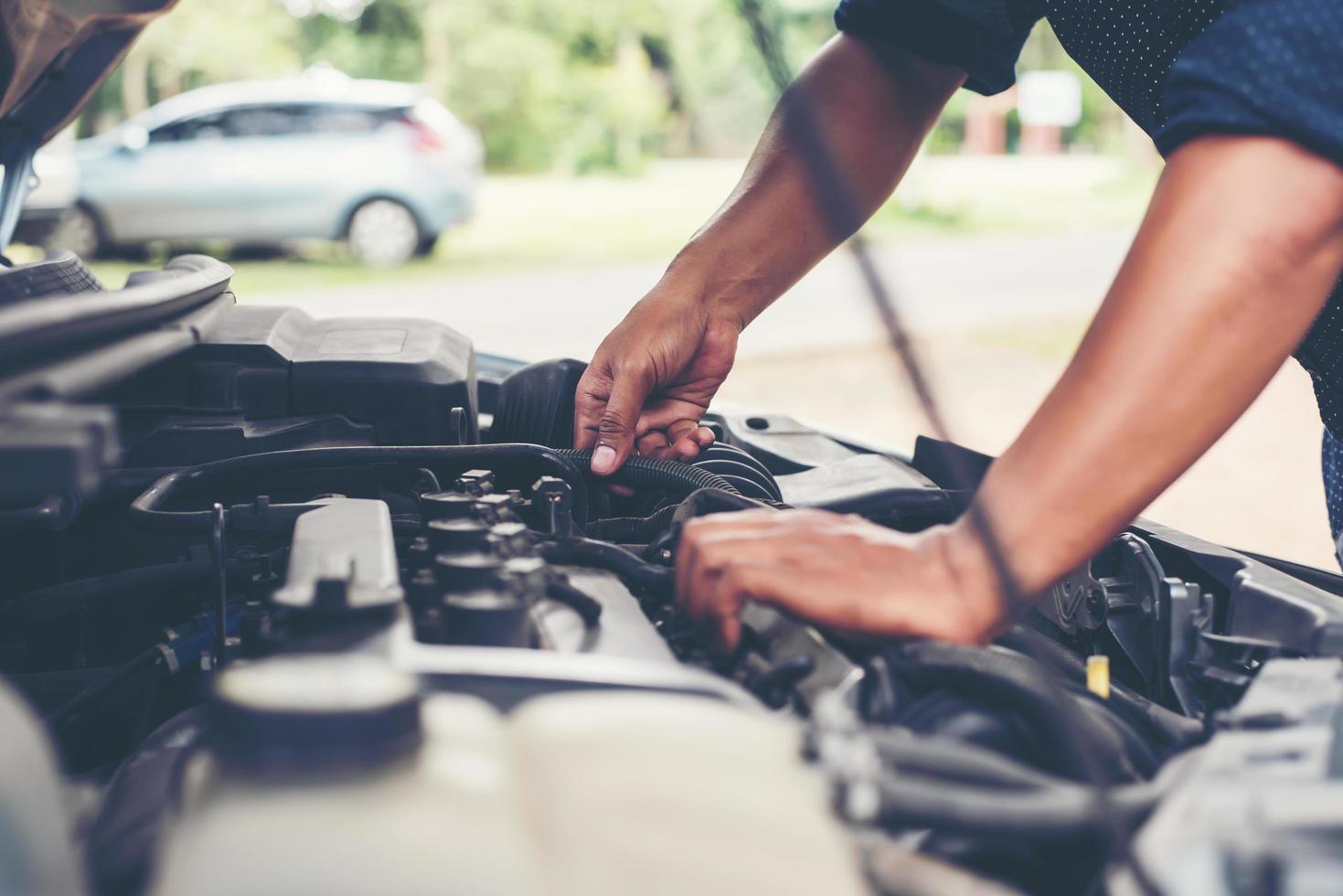 homem verificando o motor de um carro foto