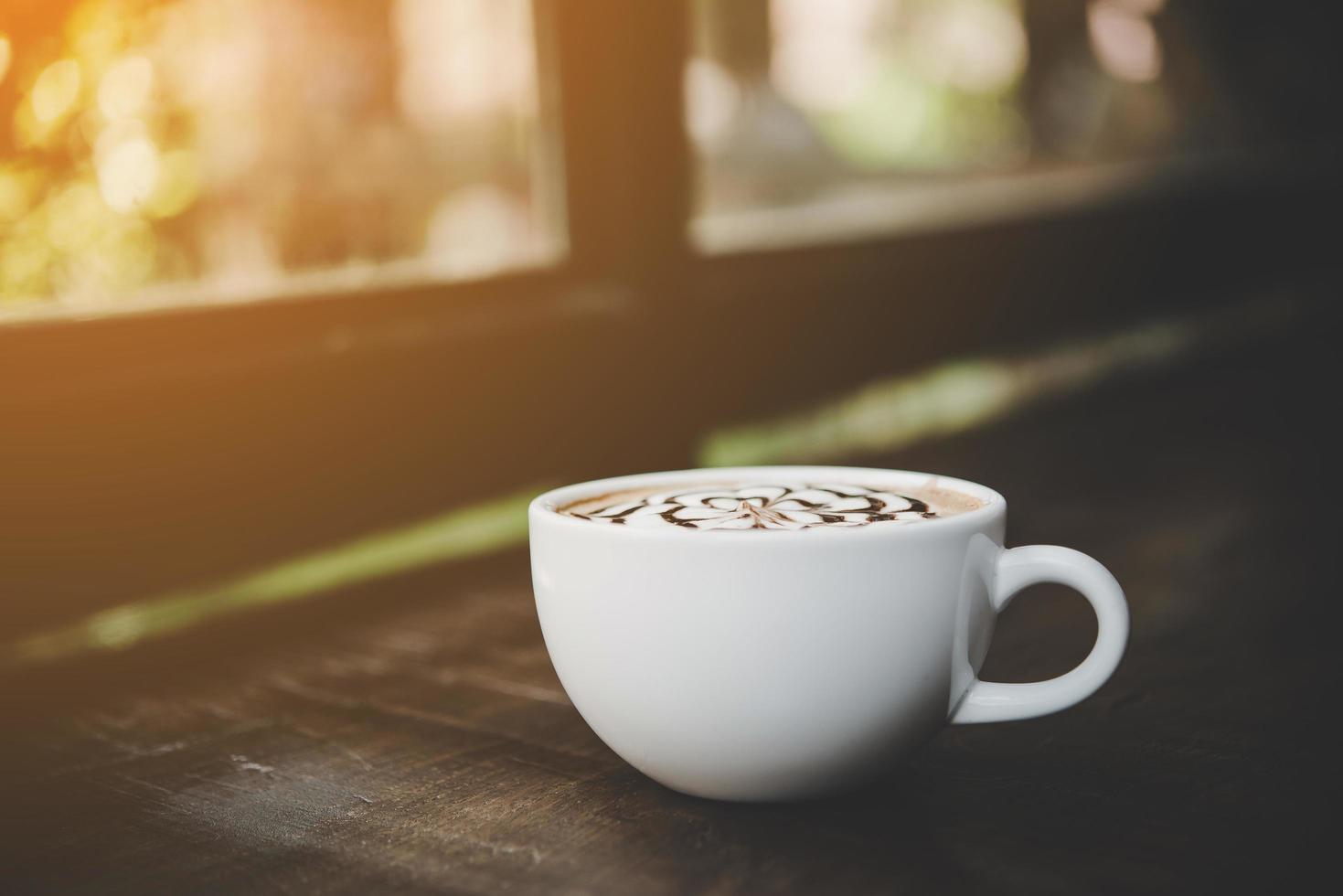 uma xícara de café em uma mesa de madeira foto