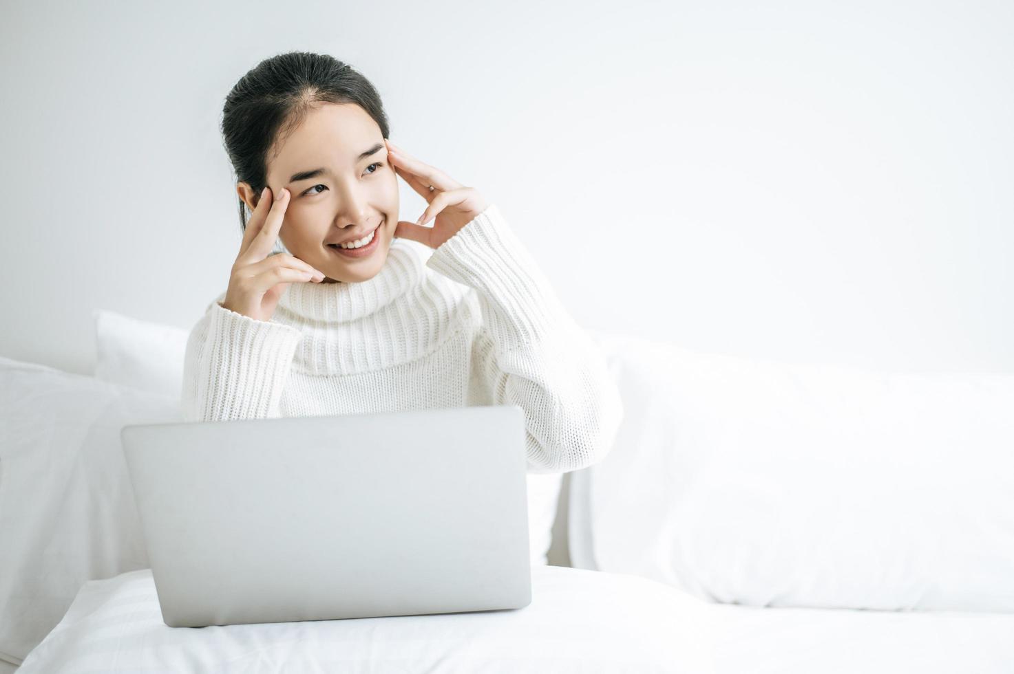 jovem vestindo uma camisa branca brincando em seu laptop foto