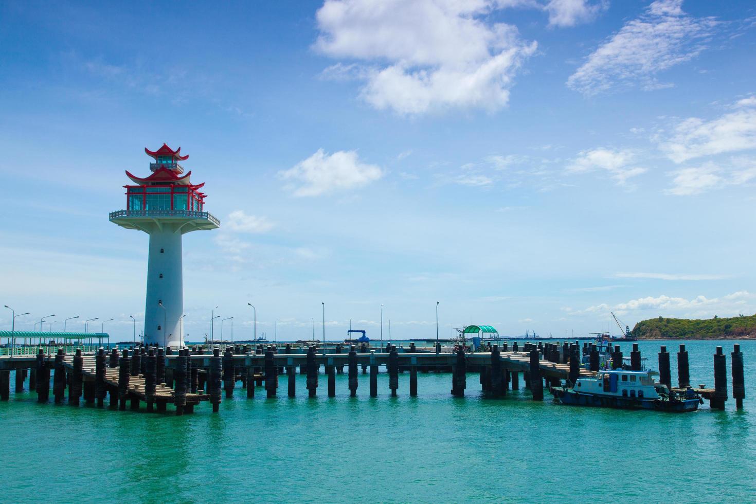 farol e ponte estendendo-se para o mar foto