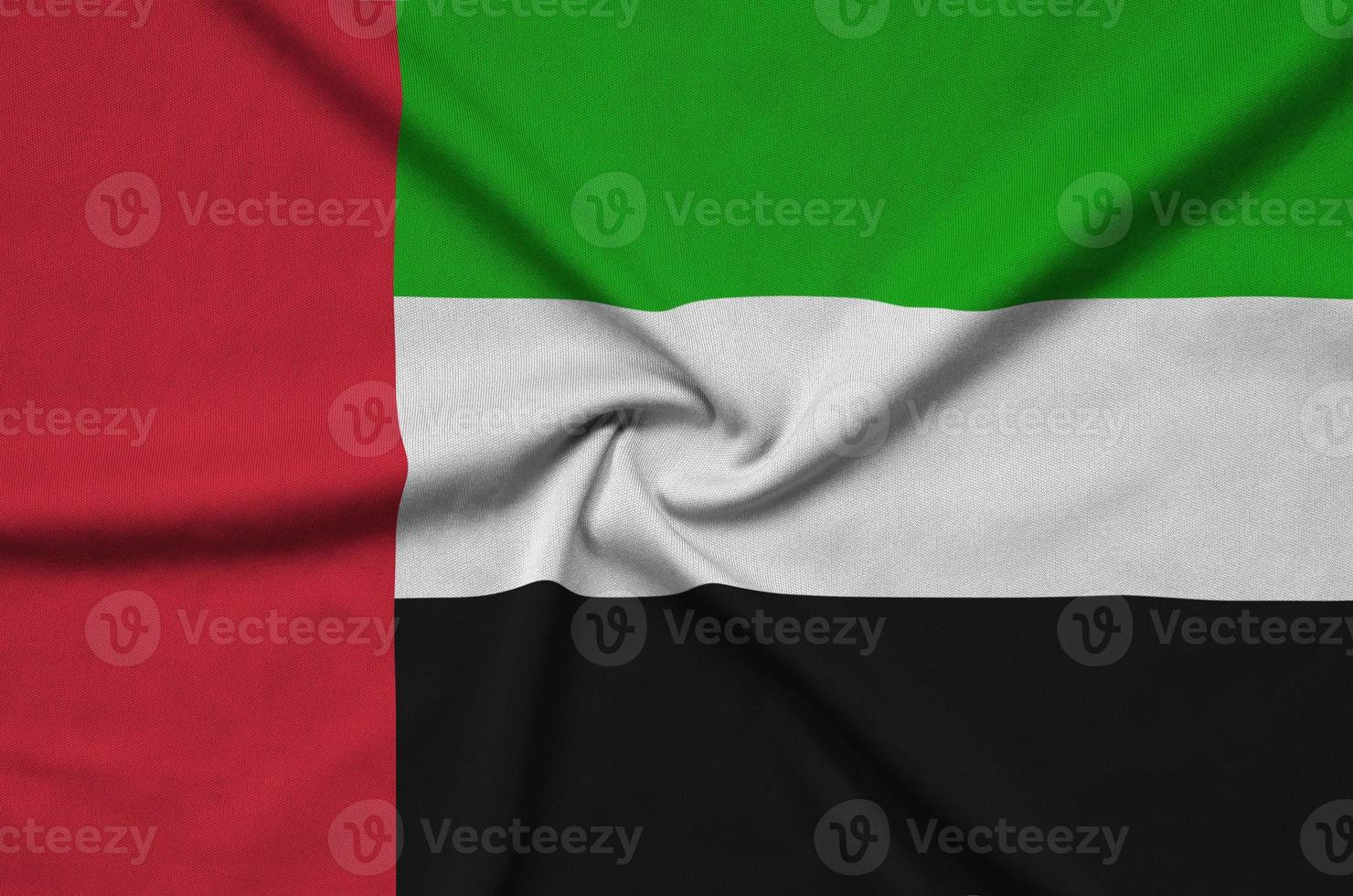 A bandeira dos emirados árabes unidos é retratada em um tecido esportivo com muitas dobras. bandeira da equipe esportiva foto