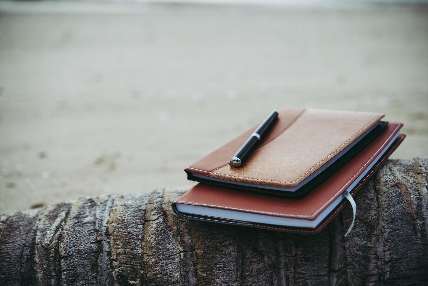 um caderno e caneta na praia foto