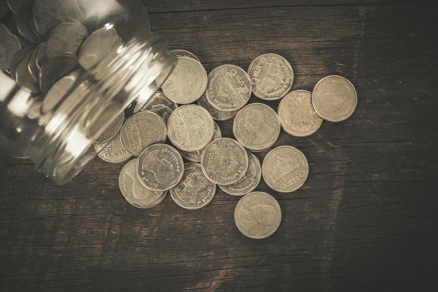 conceito de economia de dinheiro de coleta de moedas em um fundo de madeira foto